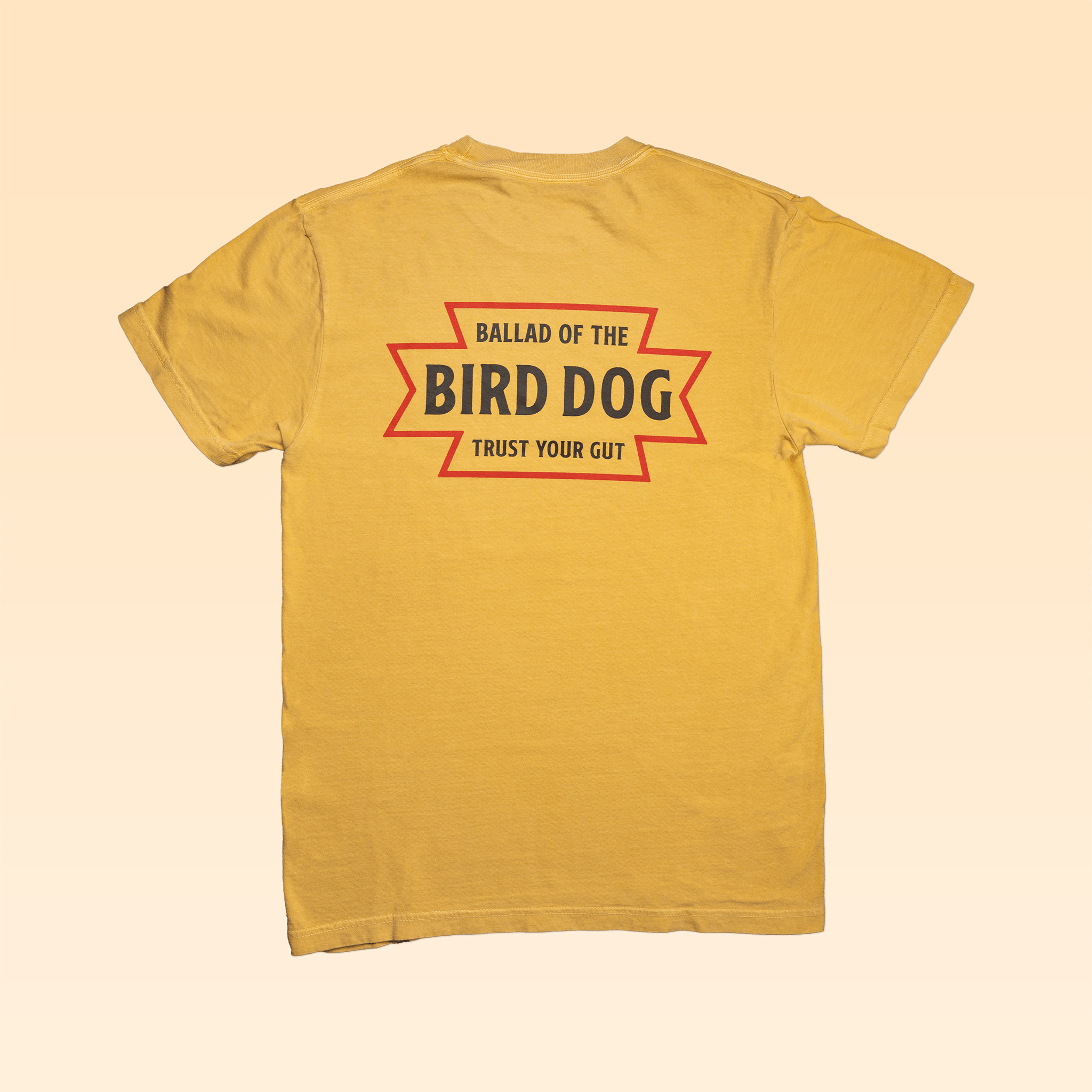 The Shop Shirt | Desert Dog by Ballad of the Bird Dog features bold black and orange "Trust Your Gut" lettering on the back—an ideal adventure tee inspired by the American West.