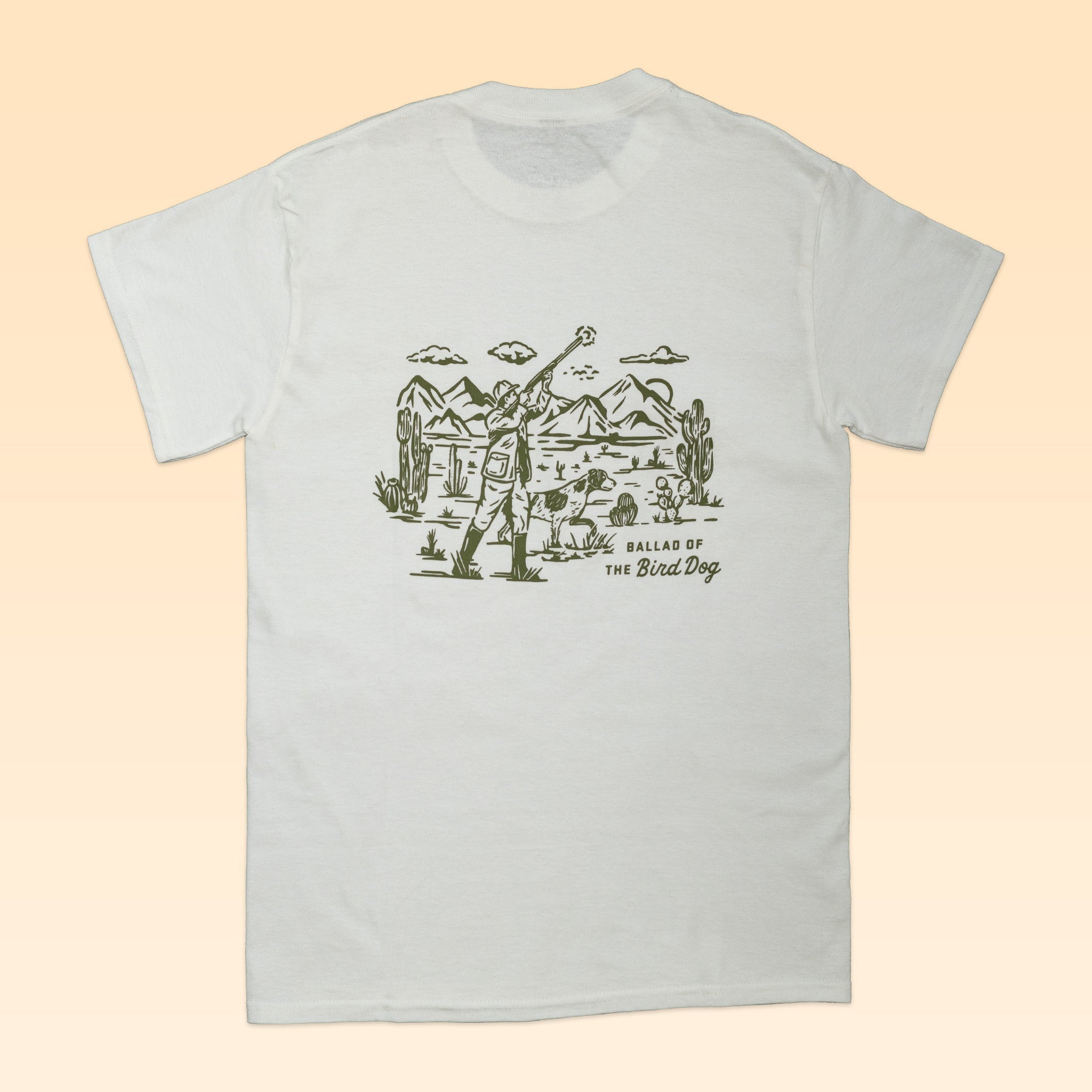 The Shop Shirt | Desert Hunt by Ballad of the Bird Dog features a white tee with a line drawing of a person and dog in a desert, plus "Ballad of THE Bird Dog" text. Perfect outdoor shirt for dog lovers.