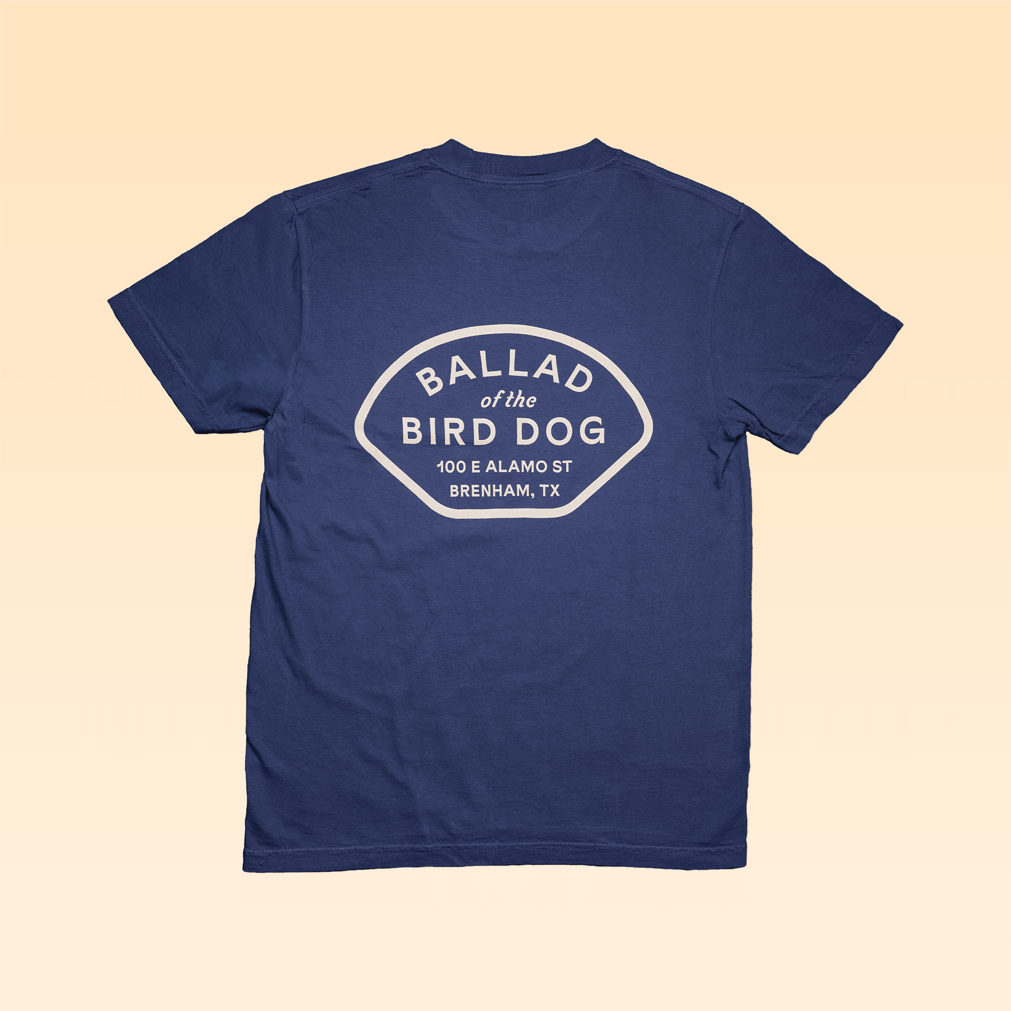 The Shop Shirt | Home Base by Ballad of the Bird Dog is a navy Comfort Colors tee with a bold white back graphic: "BALLAD of the BIRD DOG, 100 E ALAMO ST, BRENHAM, TX.