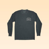 The Ballad of the Bird Dog Shop Shirt Long Sleeve | Rattlesnake Oval is a charcoal gray shirt with white print on the left chest, shown on a light beige background.