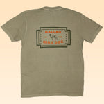 The Ballad of the Bird Dog Shop Shirt | Neon Revival is a khaki tee with a rectangular back graphic featuring a dog illustration and "Ballad of the Bird Dog" text, giving off retro logo shirt vibes for fans of nostalgic style.