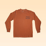 The Ballad of the Bird Dog Shop Shirt in Pheasant Flush, featuring blue "Ballad of the Bird Dog" text on the left chest, is displayed flat on a beige gradient background.