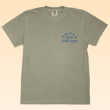 The Ballad of the Bird Dog Shop Shirt features a rattlesnake oval logo and blue text on the gray short-sleeve tee—blending classic style and unique charm.