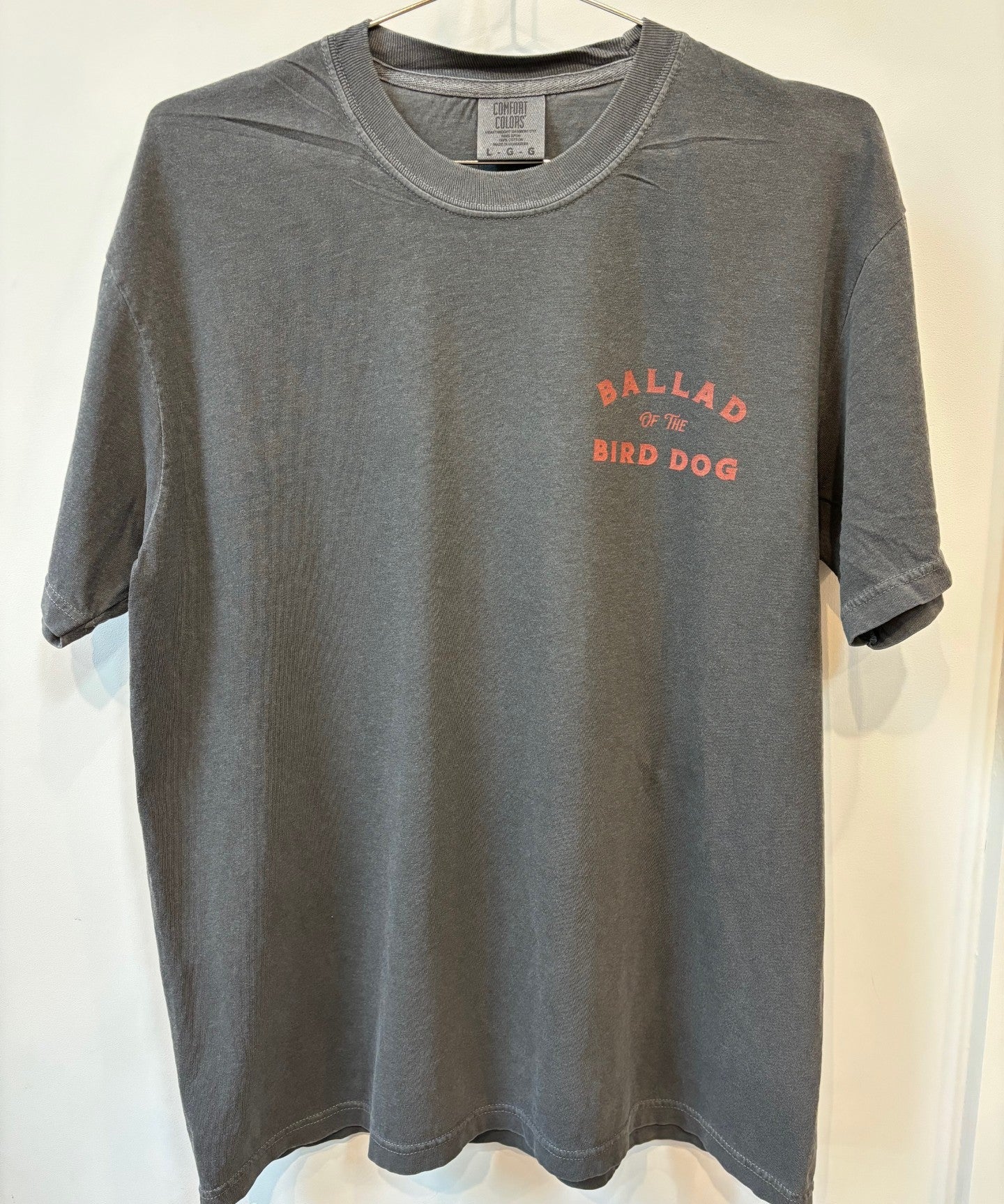 The Shop Shirt | Retriever by Ballad of the Bird Dog is a gray T-shirt featuring "BALLAD OF THE BIRD DOG" in red on the left chest.