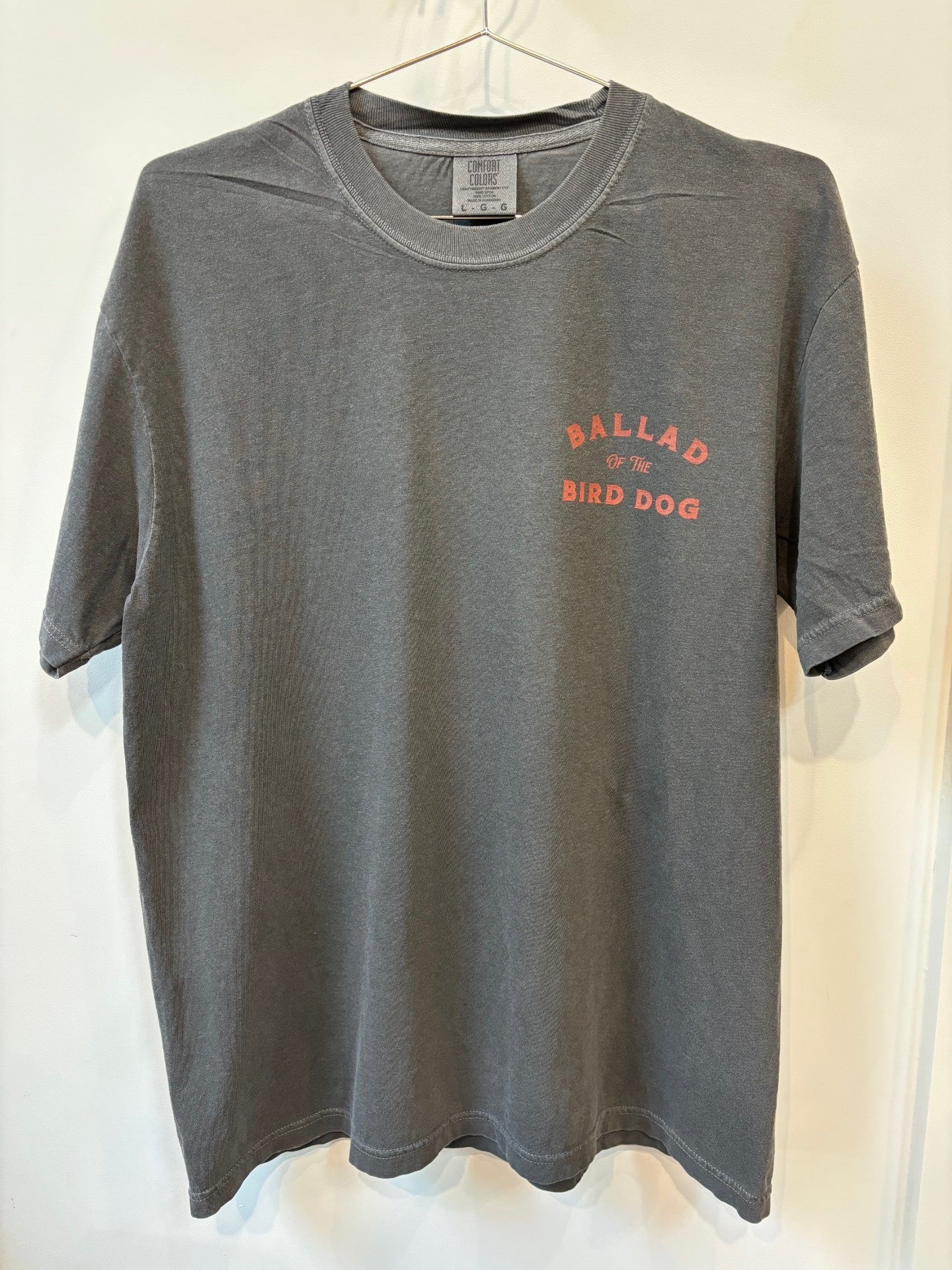 The Shop Shirt | Retriever by Ballad of the Bird Dog is a gray T-shirt featuring "BALLAD OF THE BIRD DOG" in red on the left chest.