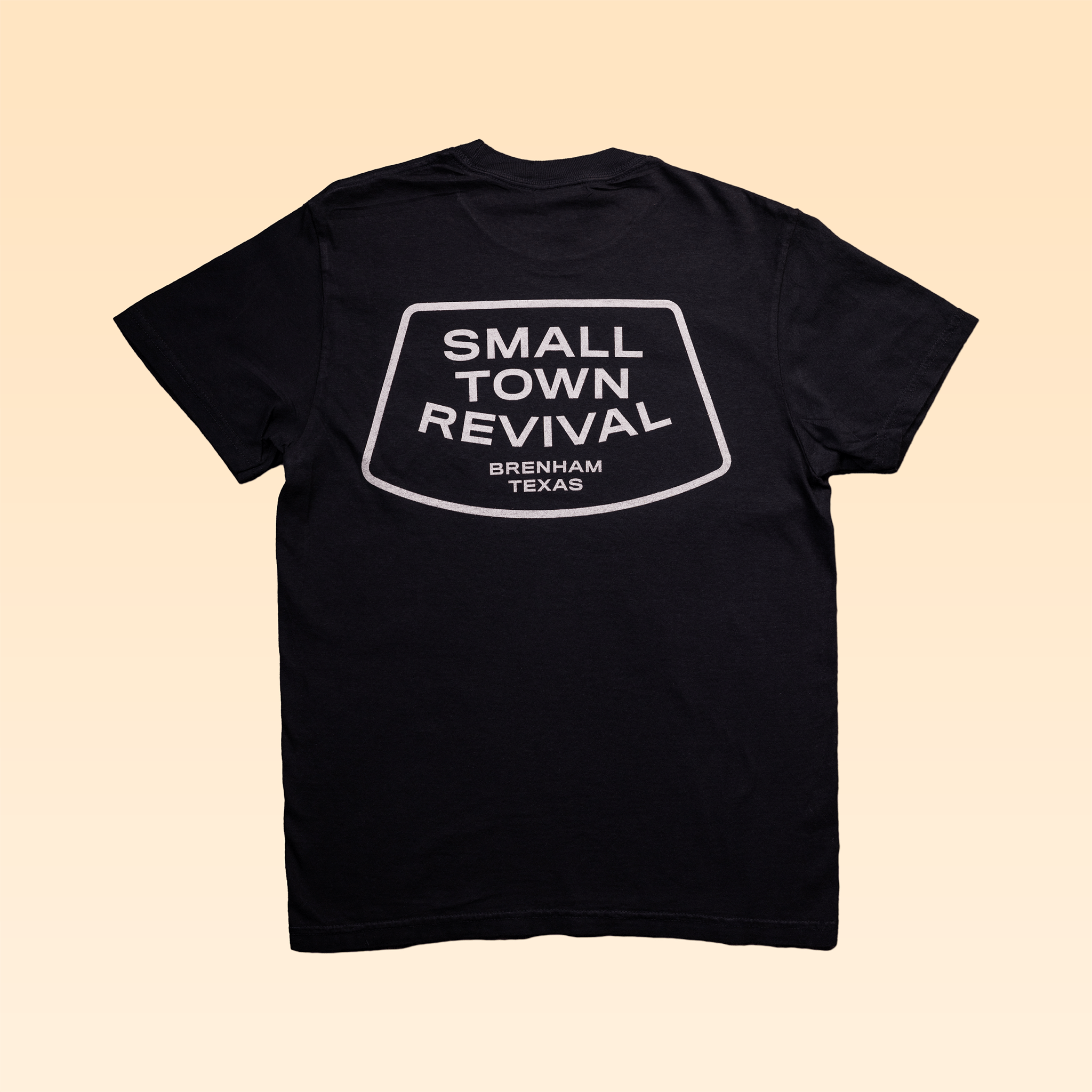 The Ballad of the Bird Dog Shop Shirt | Small Town Revival Glory is a black Comfort Colors tee with a bold patch-style back graphic reading "SMALL TOWN REVIVAL BRENHAM TEXAS" in white.