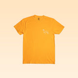The Shop Shirt | Upland by Ballad of the Bird Dog is a plain yellow tee with a small white outline graphic of a dog on the left chest, shown on a light yellow background.