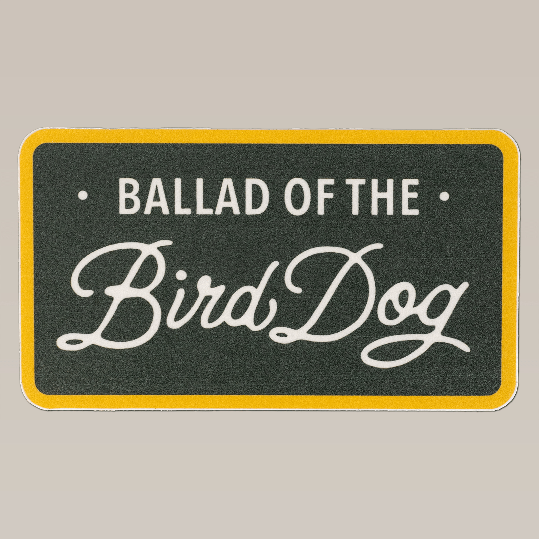 A rectangular sign with a yellow border and dark background features "BALLAD OF THE Bird Dog" in white (with "Bird Dog" in cursive), like the style on our Ballad of the Bird Dog Shop Sticker | Bird Dog Plate.
