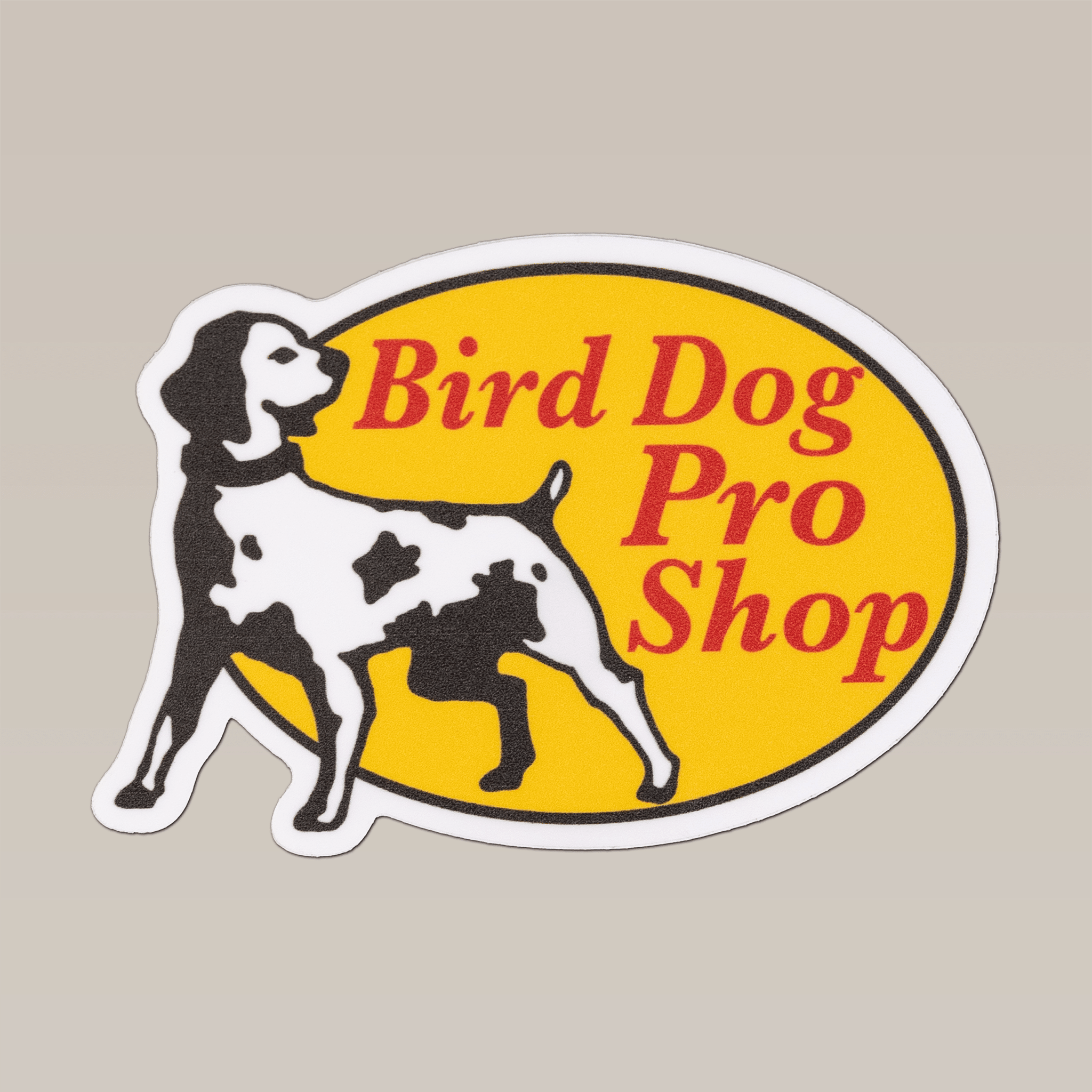 Shop Sticker by Ballad of the Bird Dog features a black and white dog beside a yellow circle with red "Bird Dog Pro Shop" text on a light beige background—great for coolers or outdoor gear.