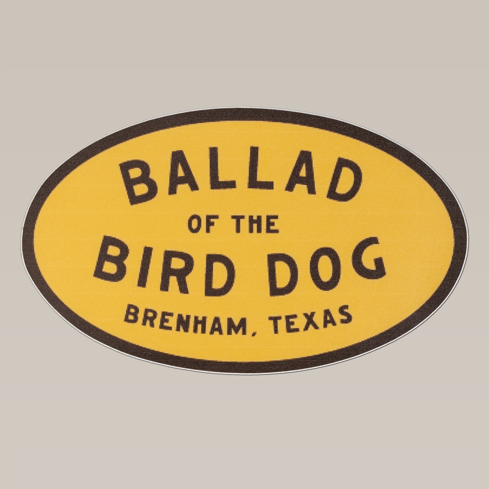 The Shop Sticker | Classic Oval by Ballad of the Bird Dog is a 5-inch yellow oval sticker featuring "Ballad of the Bird Dog, Brenham, Texas" in black text—ideal as a cooler decal.