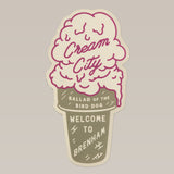 This Cream City sticker from Ballad of the Bird Dog is shaped like an ice cream cone and features "Cream City," nodding to Brenham, home of Blue Bell Creameries.
