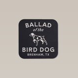 Shop sticker featuring Ballad of the Bird Dog's full lockup logo in white text with a standing dog illustration and "Brenham, TX" on a black background.