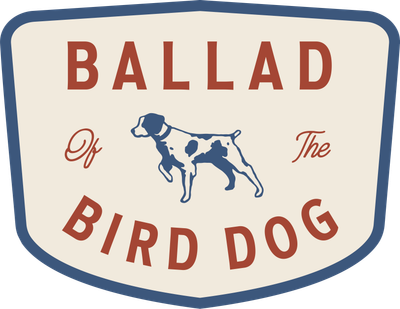 The Ballad of the Bird Dog Shop Sticker features a shield-shaped design with blue trim, a blue dog on a cream background, and "BALLAD Of The BIRD DOG" text—capturing classic Americana style. Brand: Ballad of the Bird Dog.