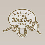 The Ballad of the Bird Dog Shop Sticker features a rattlesnake oval wrap design and "Ballad of the Bird Dog Texas" text, inspired by the Desert Series.