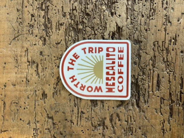 Shop Stickers by Mescalito Coffee featuring "WORTH THE TRIP MESCALITO COFFEE" and a sunburst design—ideal for collectors or fans of unique small town coffee shop merchandise.