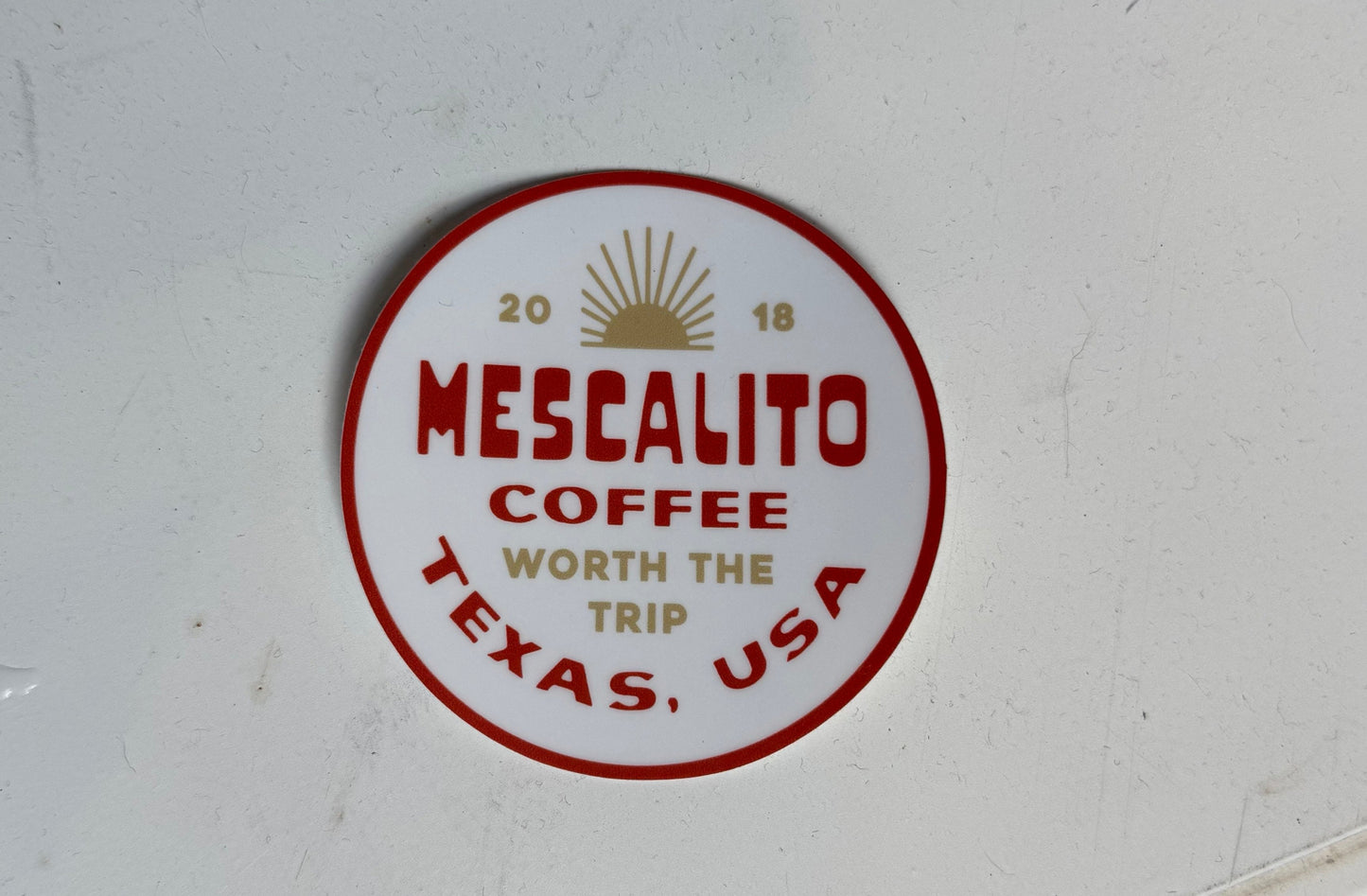 The Shop Stickers | Mescalito Coffee by Mescalito Coffee feature a round design with "Mescalito Coffee Worth the Trip, Texas, USA, 2018" and a sun graphic on white—ideal for capturing coffee shop charm and small-town vibes.