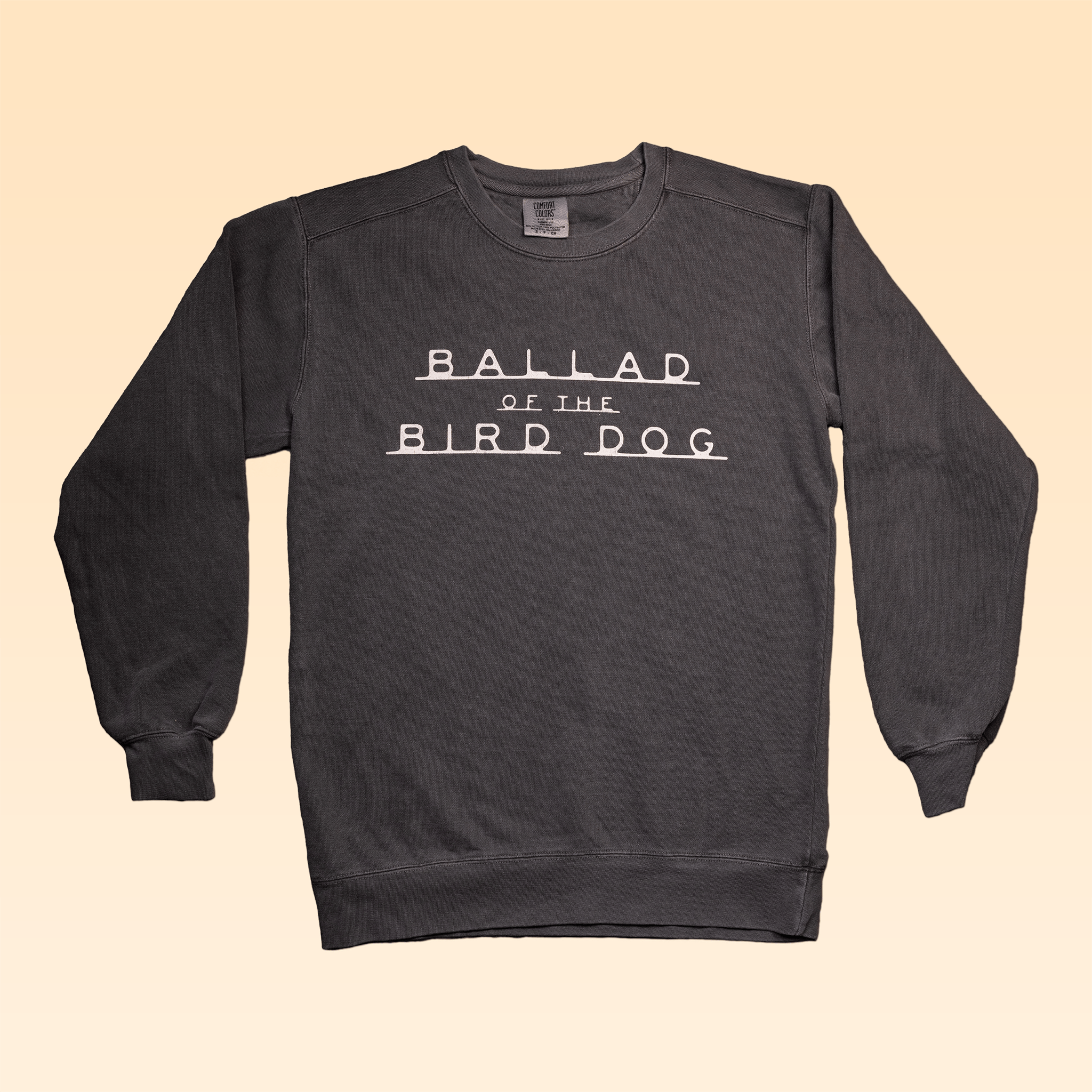 The Ballad of the Bird Dog Terlingua Sweater is a dark gray Comfort Colors sweatshirt featuring "BALLAD OF THE BIRD DOG" in bold white letters across the front.