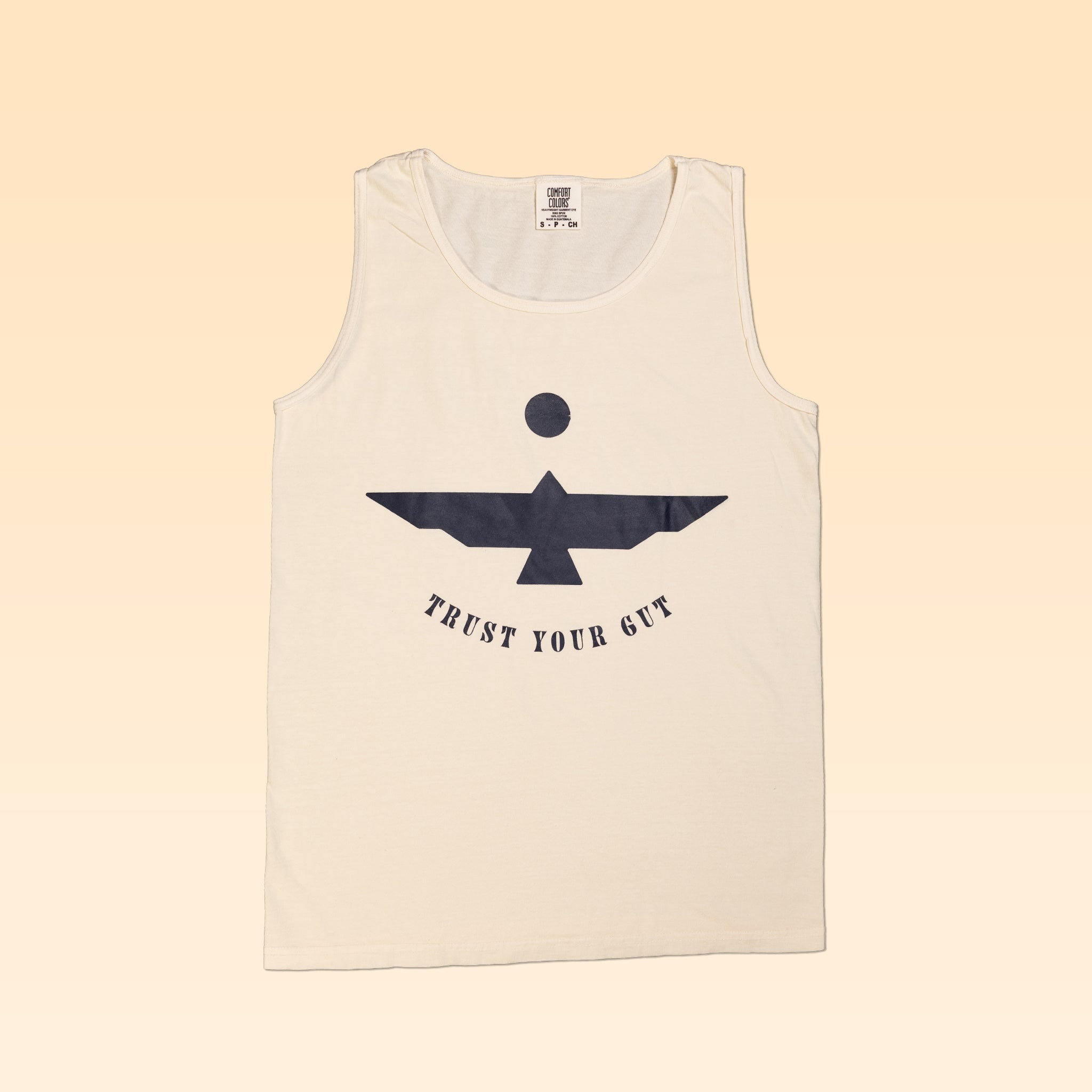 The Shop Tank | Thunderbird by Ballad of the Bird Dog features a beige, garment-dyed fabric with a black abstract bird and “TRUST YOUR GUT” graphic, from Comfort Colors, shown on a light gradient background.