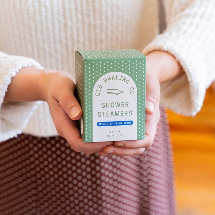 Person holding Old Whaling Co. Shower Steamers in Spearmint & Eucalyptus, ready to enjoy a spa-like shower with the refreshing scent of spearmint and eucalyptus.