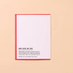 The "Shrimply Obsessed With You" greeting card by And Here We Are features a red border, the text "AND HERE WE ARE," and printing details with a website at the bottom, all set against a beige background.