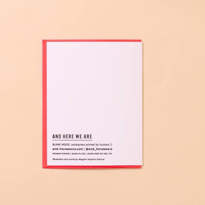 The "Shrimply Obsessed With You" greeting card by And Here We Are features a red border, the text "AND HERE WE ARE," and printing details with a website at the bottom, all set against a beige background.