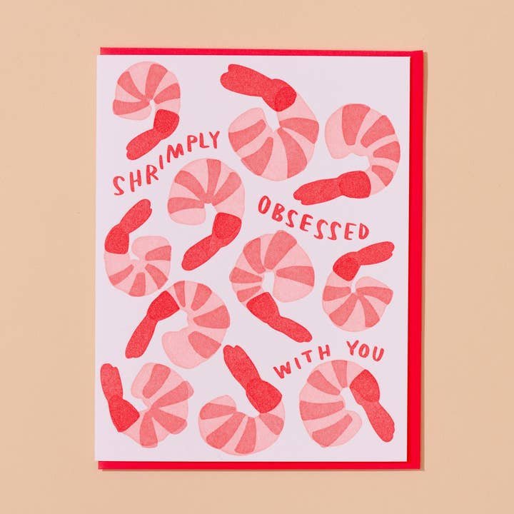 The “Shrimply Obsessed With You” card by And Here We Are features playful shrimp illustrations and a fun message on a pink background—an ideal handmade greeting for anyone who loves puns and unique cards.