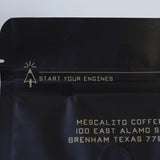 A bag of Mescalito Coffee's Single Origin Whole Coffee Beans | Chelchele displays "START YOUR ENGINES" at the top and an address in Brenham, Texas below—this medium roast showcases the unique flavors of Ethiopian coffee.