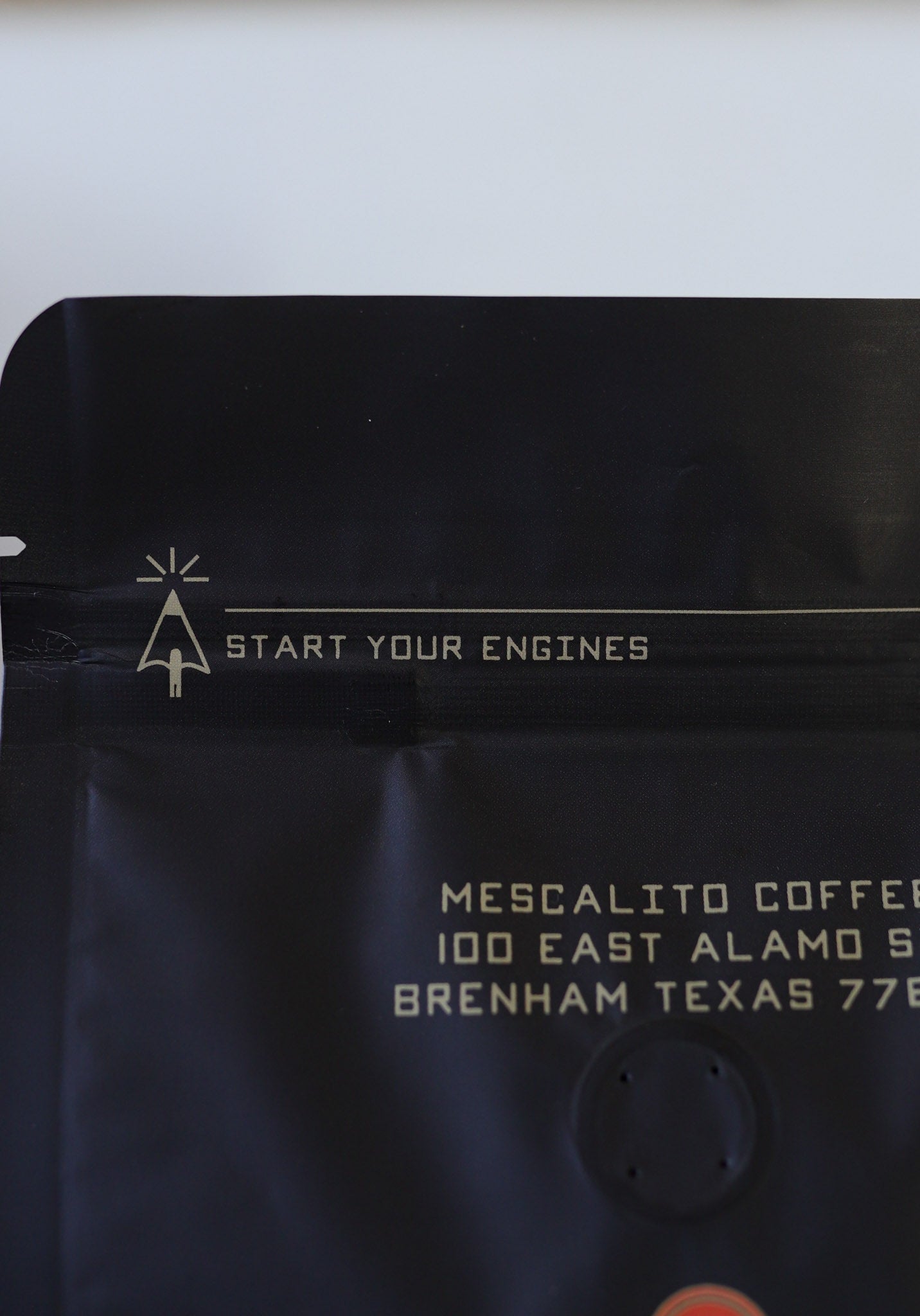 A bag of Mescalito Coffee's Single Origin Whole Coffee Beans | Chelchele displays "START YOUR ENGINES" at the top and an address in Brenham, Texas below—this medium roast showcases the unique flavors of Ethiopian coffee.