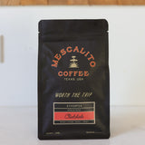 A black bag of Mescalito Coffee’s Single Origin Whole Coffee Beans | Chelchele features Ethiopia Medium Roast, crafted by the anaerobic natural process with tasting notes of peach, mango, basil, and honey and "Worth the Trip" on the label.