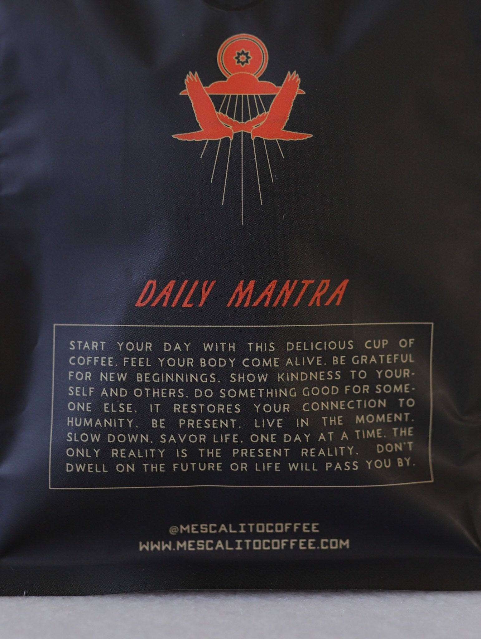 Mescalito Coffee’s Single Origin Whole Coffee Beans from Madriz, Nicaragua feature a black "Daily Mantra" bag with an inspiring message on kindness, presence, and gratitude. Medium roast organic beans; website link at the bottom.