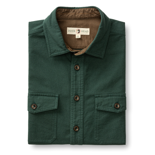The Duck Head Slater Moleskin Overshirt in forest green features two chest pockets, dark brown buttons, and a branded label inside the collar for rugged style and durability.