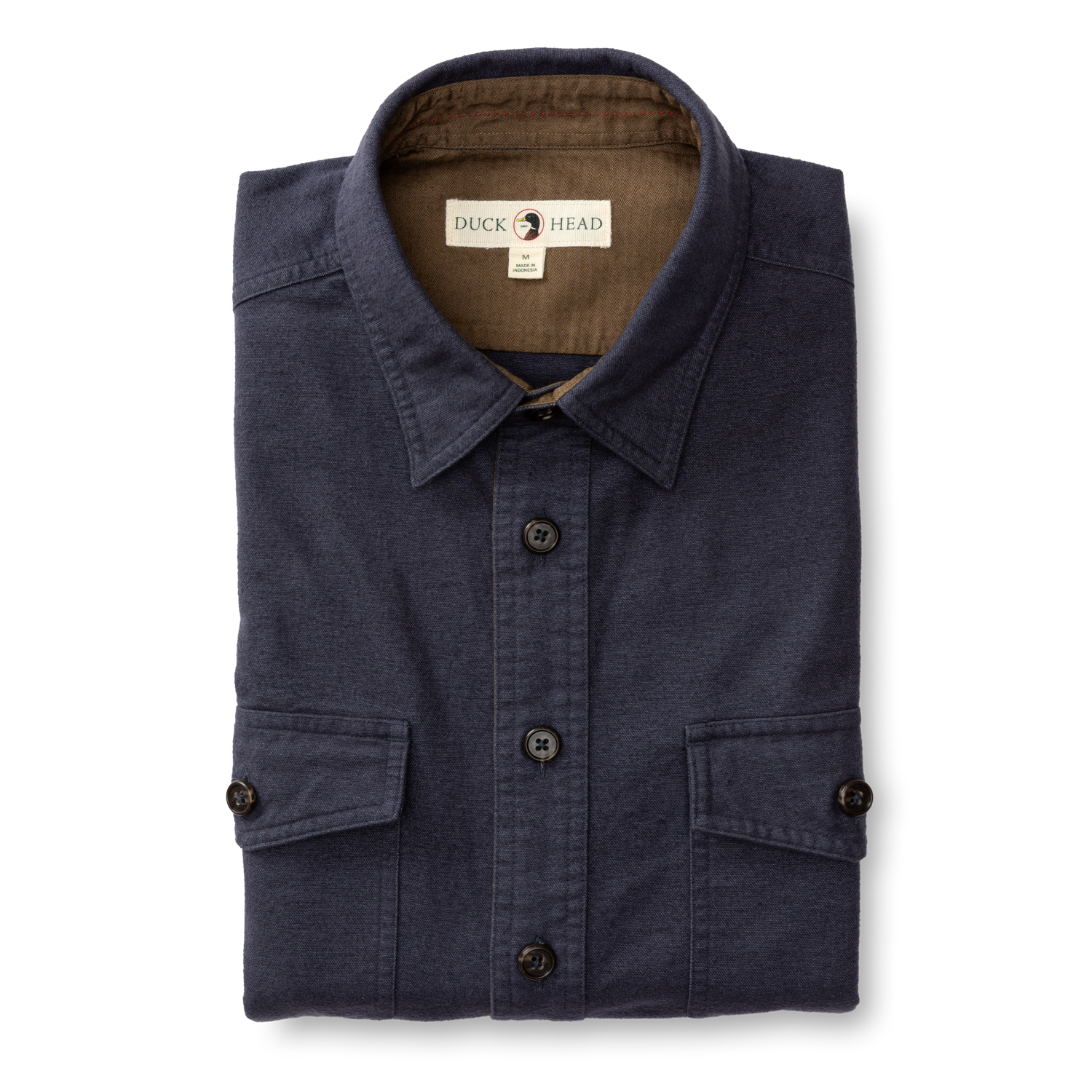 The Slater Moleskin Overshirt by Duck Head is a neatly folded navy blue shirt with two front pockets and a signature label on the collar, adding rugged style to your wardrobe.