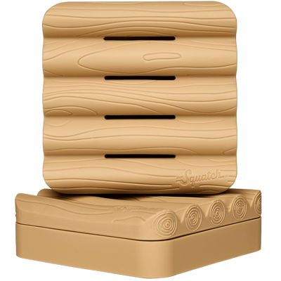 A tan, log-shaped Soap Saver by Dr. Squatch featuring carved wood grain texture, ventilation slits on top, and circular base patterns—the ideal bricc accessory for any home.