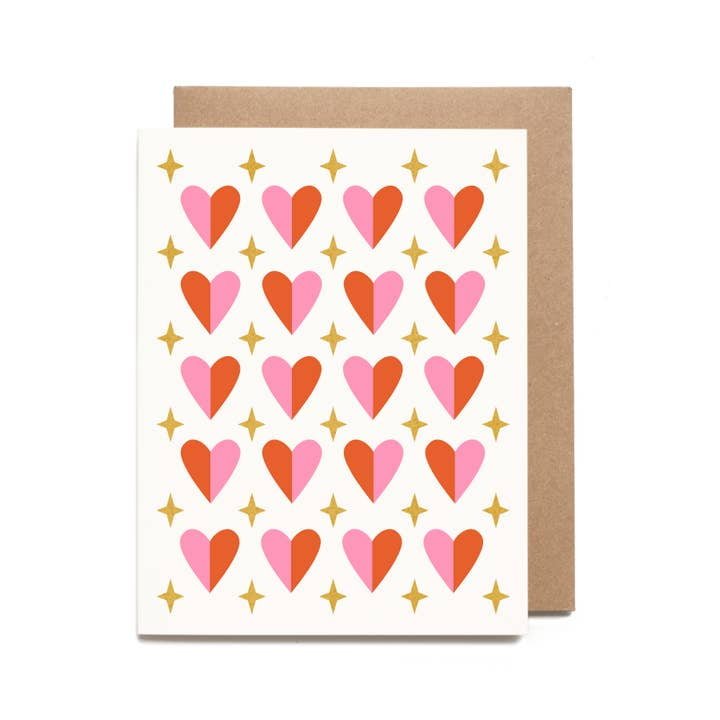 The Sparkly Heart Pattern Valentine Card by Worthwhile Paper features a pink and red heart design with gold stars, shown with a plain brown envelope in the background.