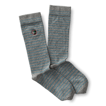 The Striped Logo Sock by Duck Head features gray and light blue stripes with a small round embroidered Duck Head logo patch near the top.