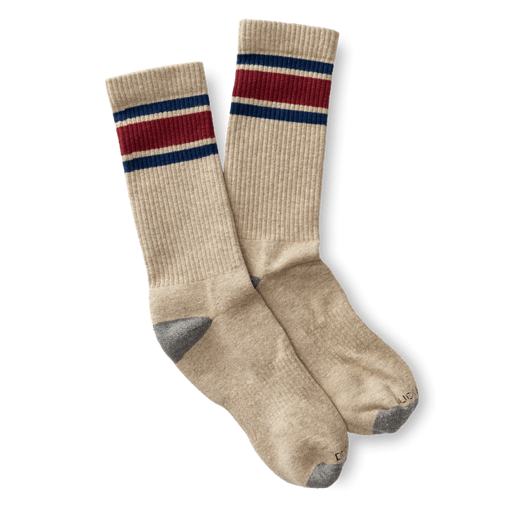 The Striped Sock by Duck Head is a beige pair with blue and red stripes at the top, plus gray toes and heels, shown on a white background.