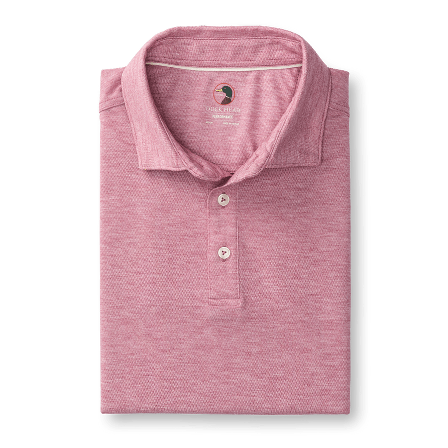 The Summerford Performance Pique Polo by Duck Head is a folded pink quick-dry polo with a collar, three buttons, and a small logo on the inside neck label, crafted from easy-care performance fabric.