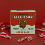 A box of Health y Sol Tallow Soap in candy cane scent sits on a red background, surrounded by small candy canes. Made with all-natural ingredients, this gentle soap soothes eczema and helps reduce acne. Brand: Health y Sol.