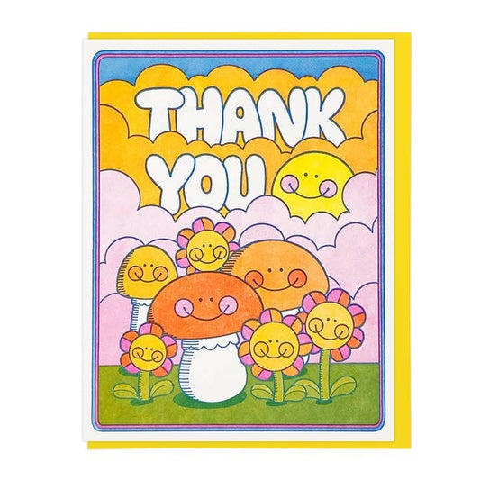 The Thank You Mushroom and Flowers card by Lucky Horse Press features smiling flowers, mushrooms, and a sun on a colorful sky. This folded greeting card is crafted from recycled cover for an eco-friendly touch.