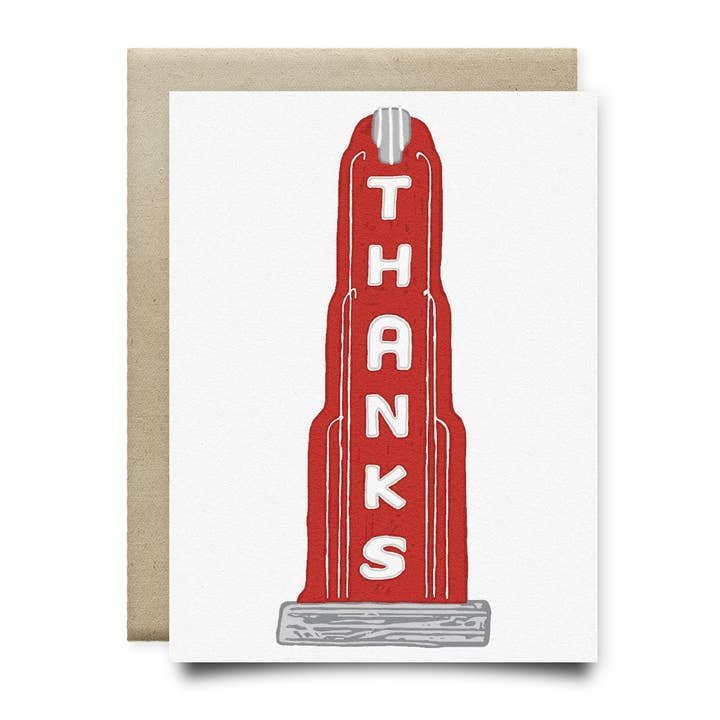 The Thanks Houston Heights Card by Anvil Cards features a hand-drawn red Art Deco-style building with "THANKS" vertically, printed on sustainable linen paper, A2 size, and comes with a brown envelope.