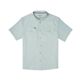 The Poncho Carolina Rig is a light blue short-sleeve button-up shirt with dual chest pockets and a small left pocket label, made from breathable, quick-drying fabric with UPF 50+ protection. Shown laid flat on a white background.