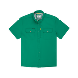 The Magnolia | Poncho by Poncho is a short-sleeve green button-up shirt with two chest pockets and a small yellow tag on the left pocket, made for breathability and shown on a white background.