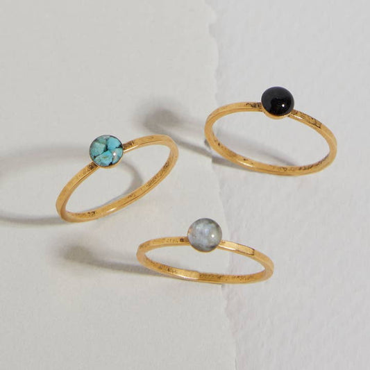 The Stacker Ring by cameoko features three gold-plated, stackable rings with round turquoise, grey, and black stones—perfect as a gemstone stacker set.