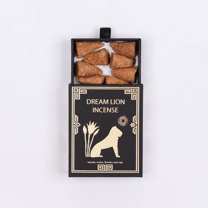 A black box labeled "The Wish Granter Incense | Dream Lion" by Dream Lion Incense features a lion illustration and holds eight brown sandalwood incense cones inside.