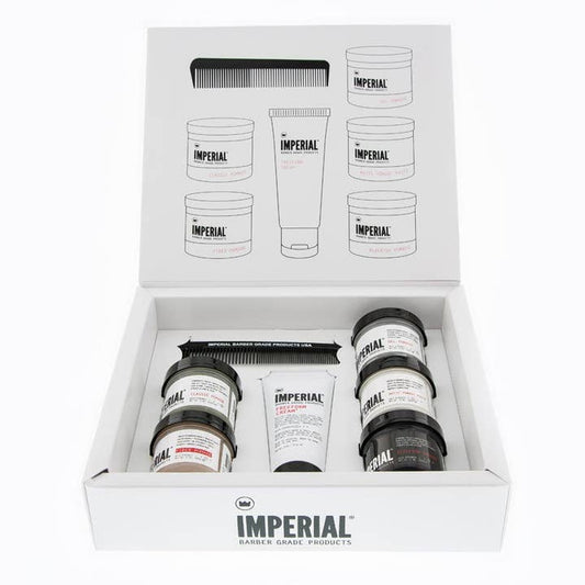 Open box showing the Travel Assortment by Imperial Barber Products—includes travel-size pomade jars, a tube, comb, and an illustrated product guide on the inside lid.