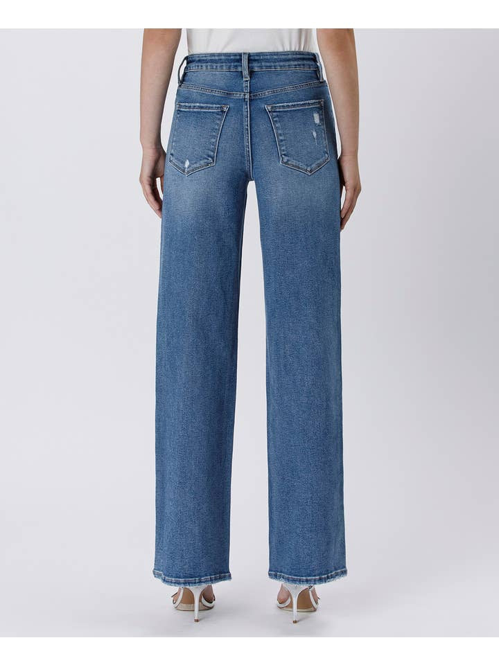 Person wearing Tummy Control Super High Rise Baggy Wide Jeans by Vervet, featuring a baggy fit and frayed hems, shown from the back against a plain background.