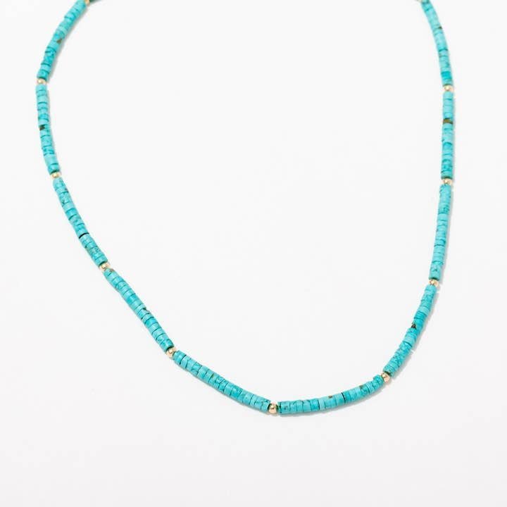 The Larissa Loden Turquoise Beaded Layering Necklace features turquoise-colored cylindrical beads and small gold spacers, shown on a white background.