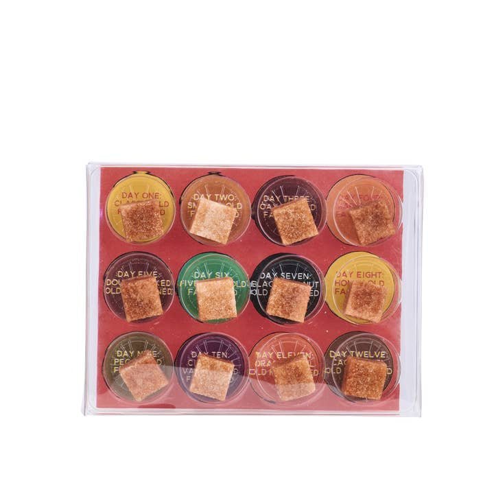 The Twelve Nights of Old Fashioneds by Yes Cocktail Co. features twelve labeled whiskey cocktail cubes in a clear box—each in its own compartment—perfect as an Advent Calendar or unique holiday gift.