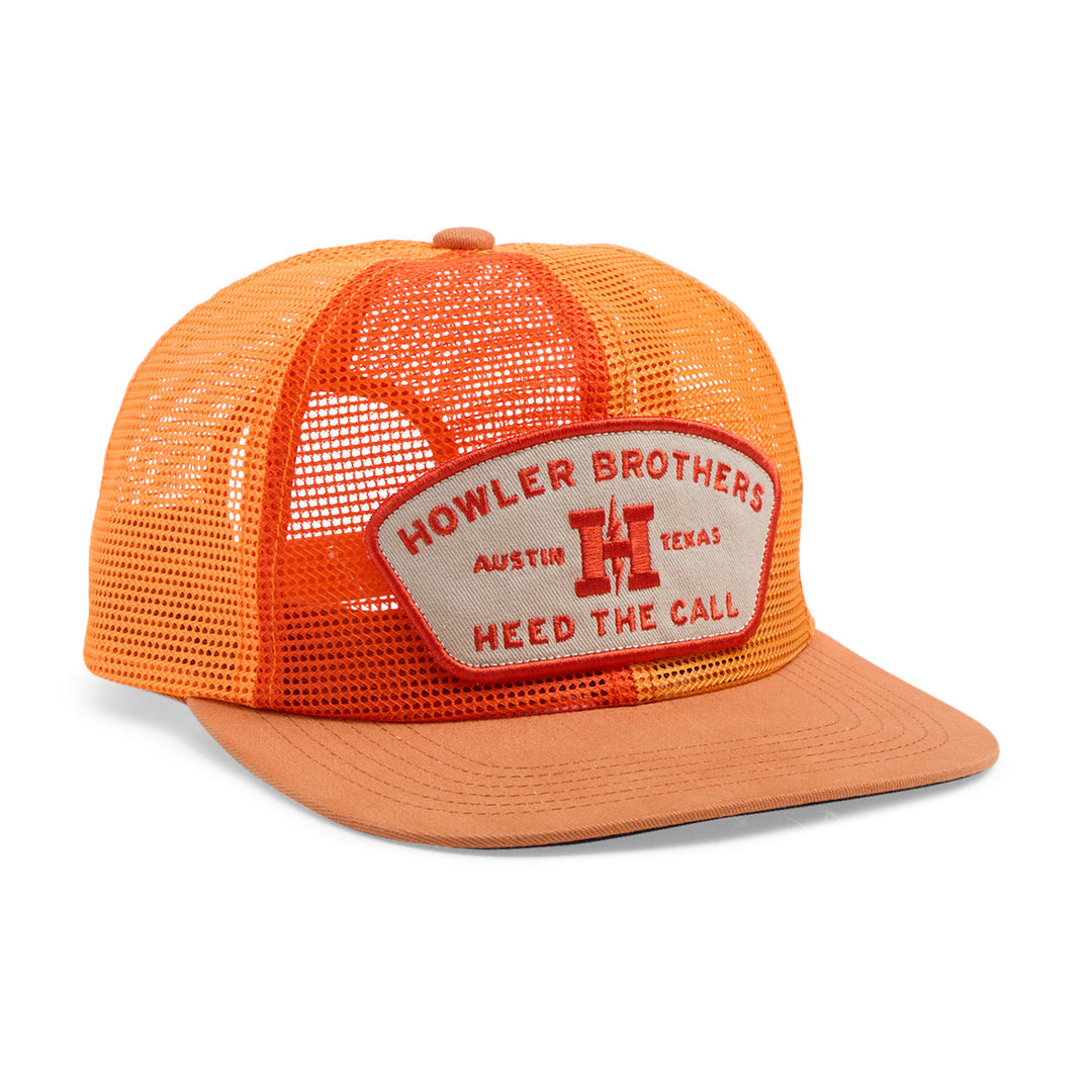 The Howler Brothers Unstructured Snapback Hat is an orange mesh trucker style with a flat brim, adjustable snapback, and a front patch reading "Howler Brothers Austin Texas Heed the Call.