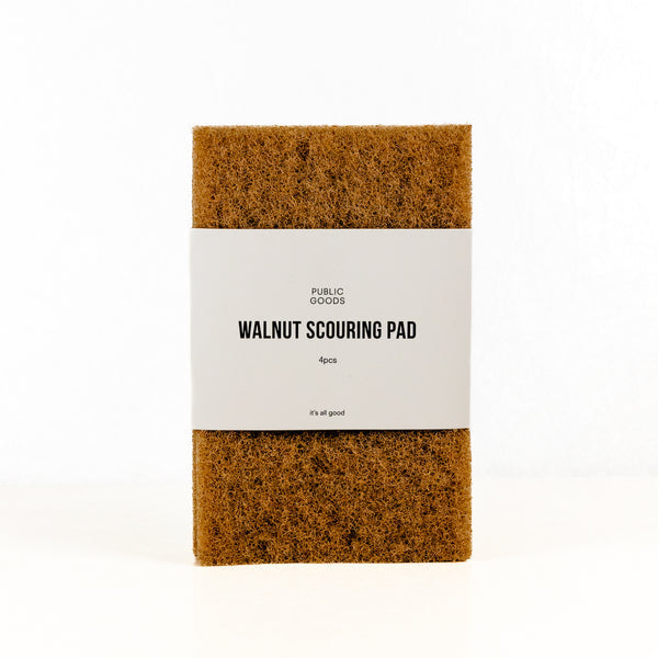 The Public Goods Walnut Scouring Pads come in a 4-pack with a white label and are made from plant-based materials—perfect for tough messes.